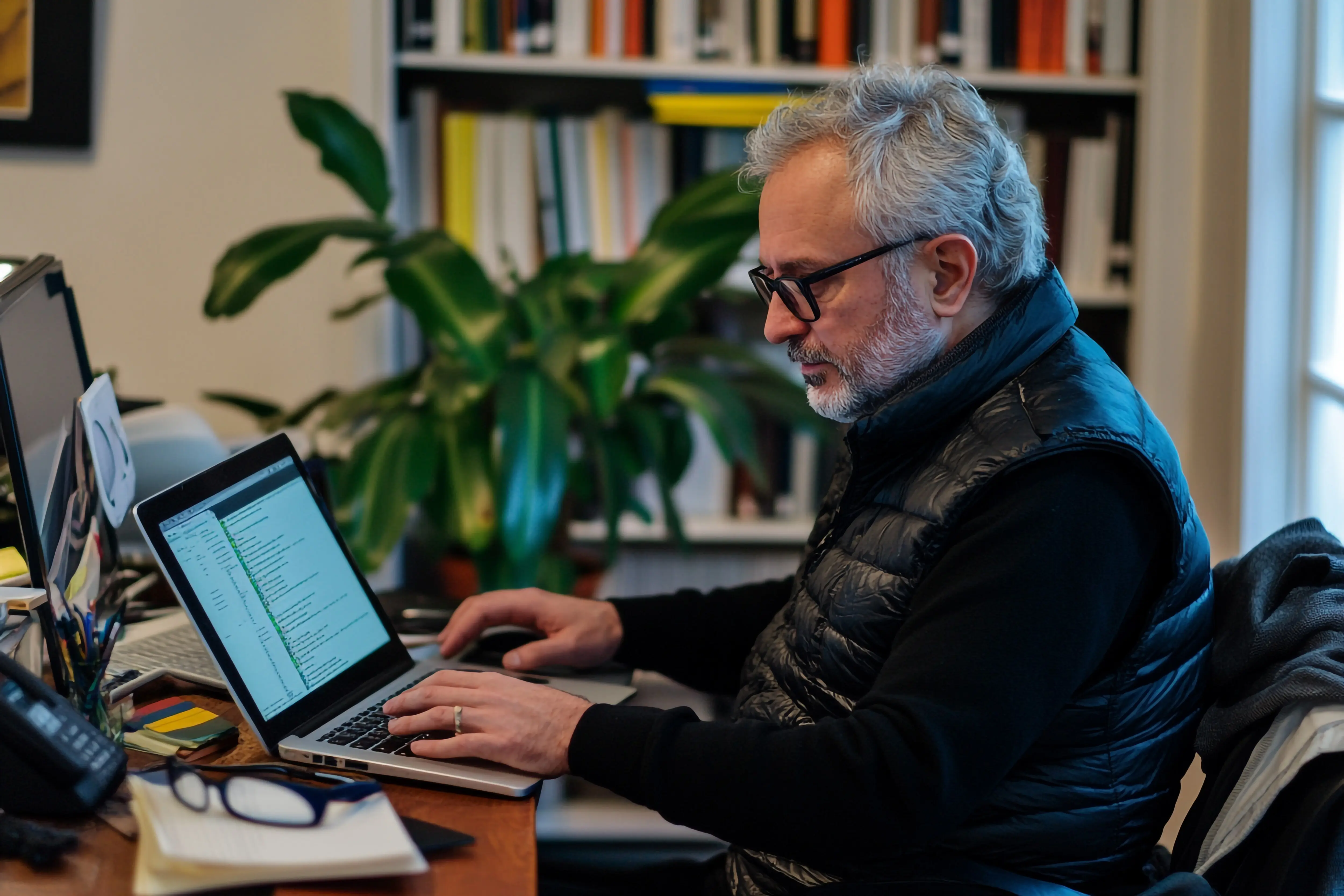 Mann arbeitet von zu Hause aus im Homeoffice an einem Laptop.